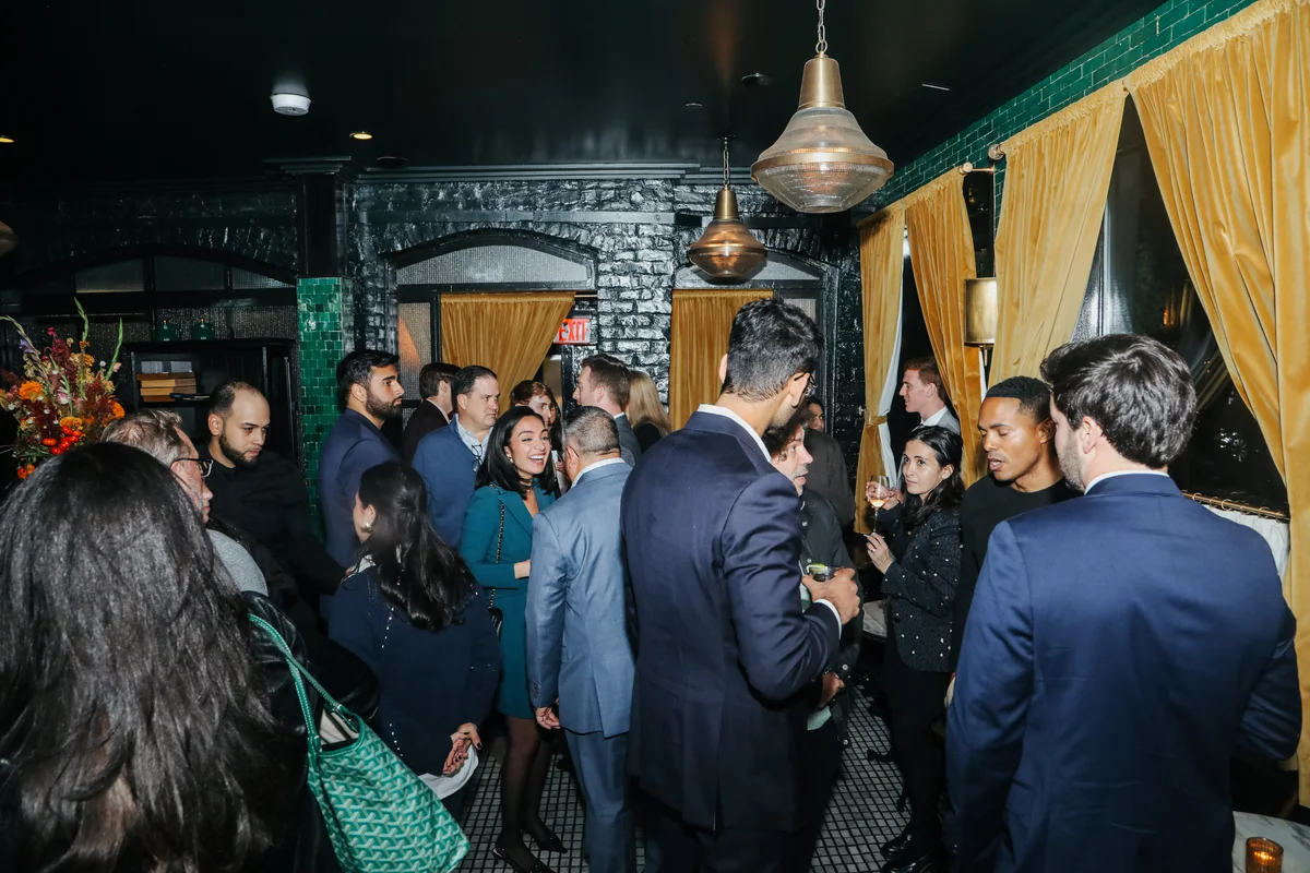 Guests mingling under green tile at The Golden Swan