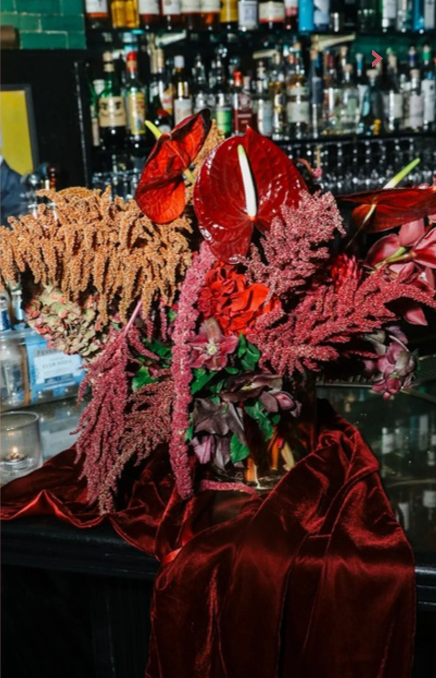 Deep red florals staged along a bar at a West Village fundraiser